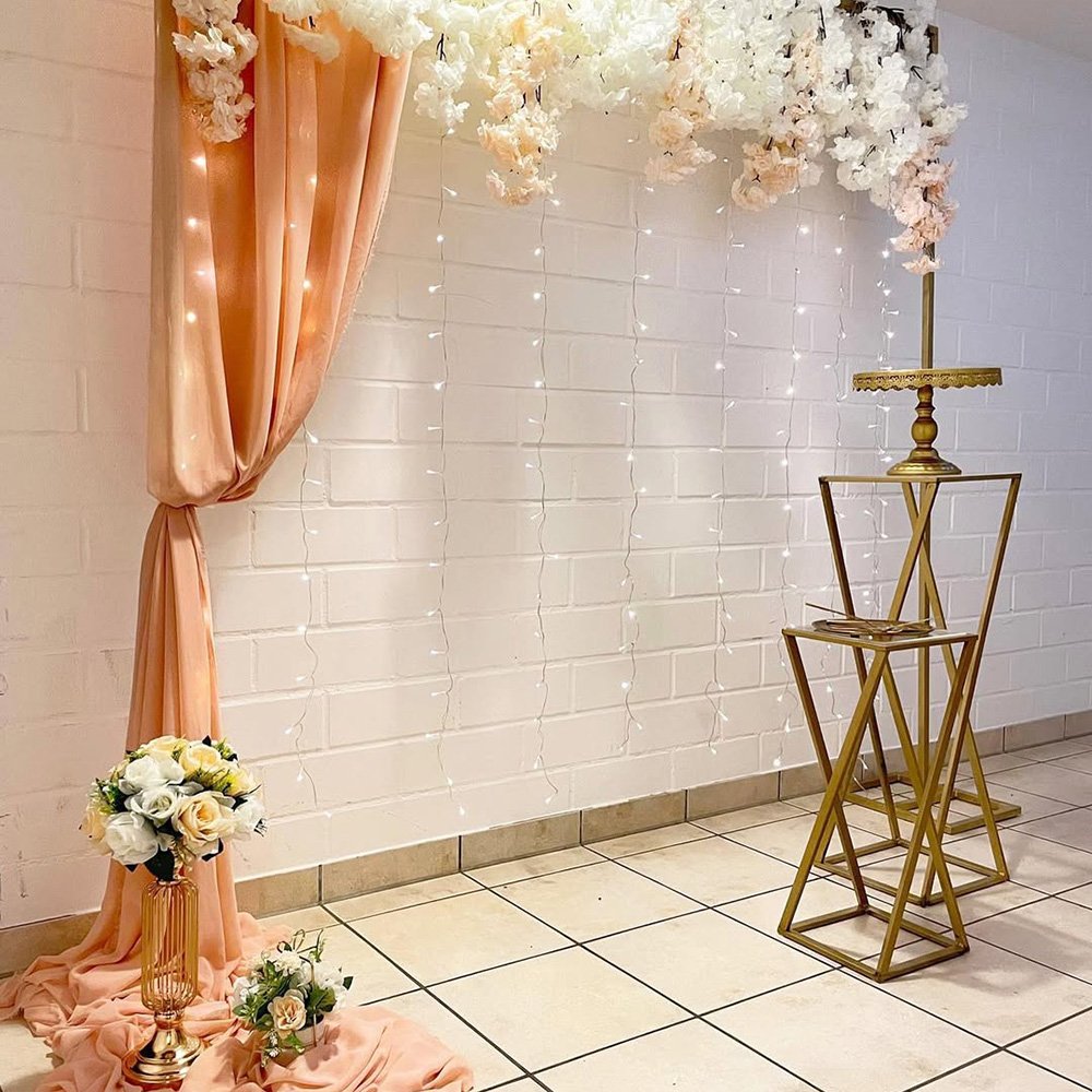 Goldene Tischdekoration mit weißen Blumen und Kerzenhaltern.