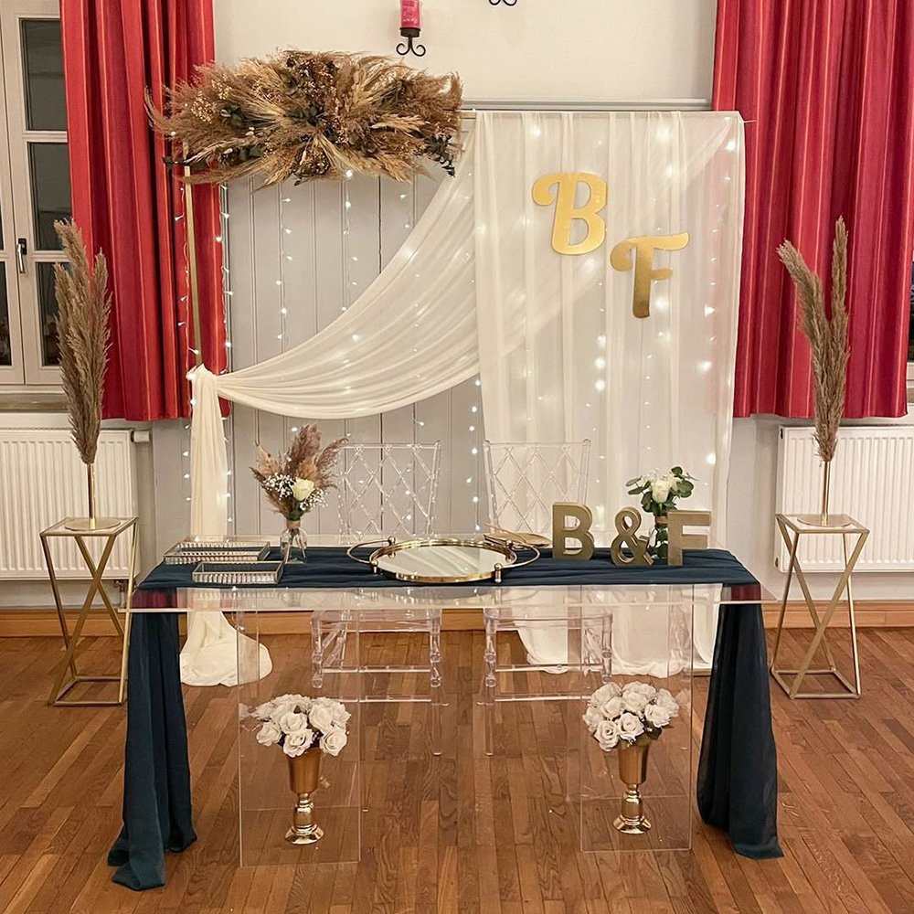 Romantisch gestaltete Fotowand mit Trockenblumen und Lichterketten.