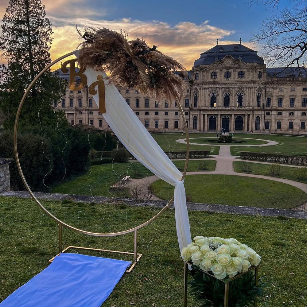 Kreisförmige Outdoor-Dekoration mit Blumen und einem Torbogen.