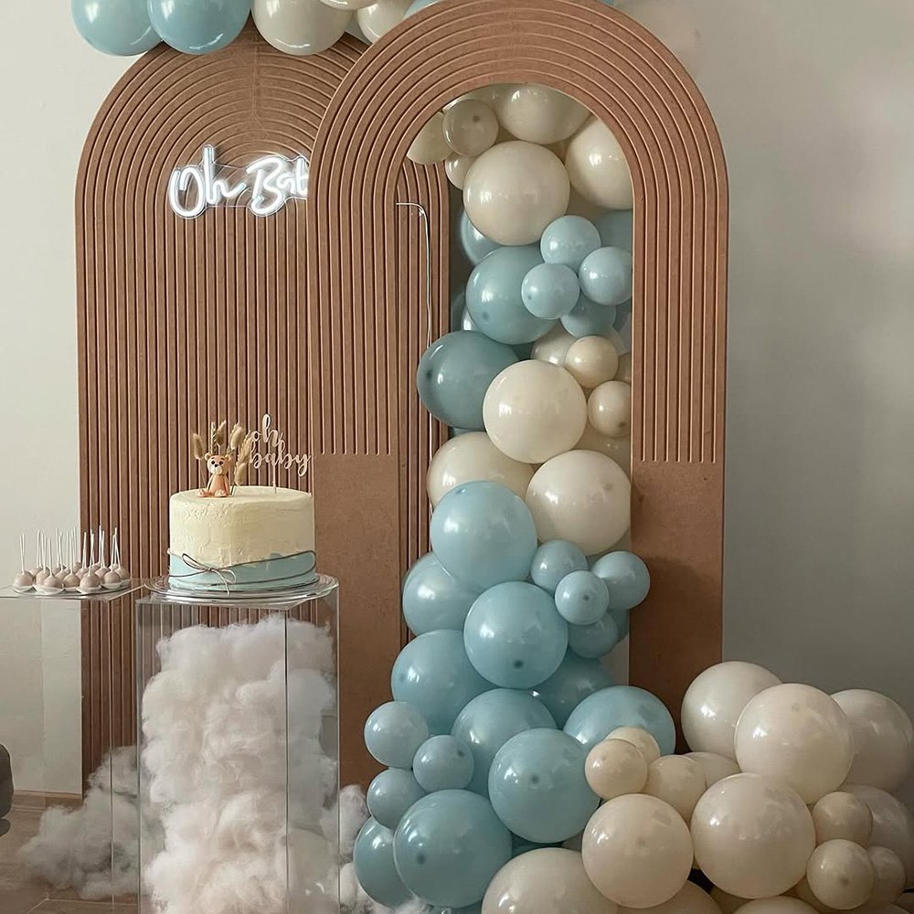 Ein Ballonbogen in Pastelltönen mit einer Hochzeitstorte darunter.