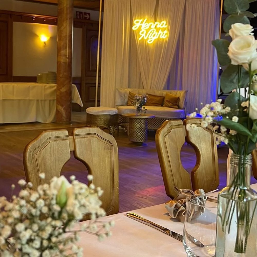 Lange Tafel mit eleganten Kerzen und Blumenarrangements.